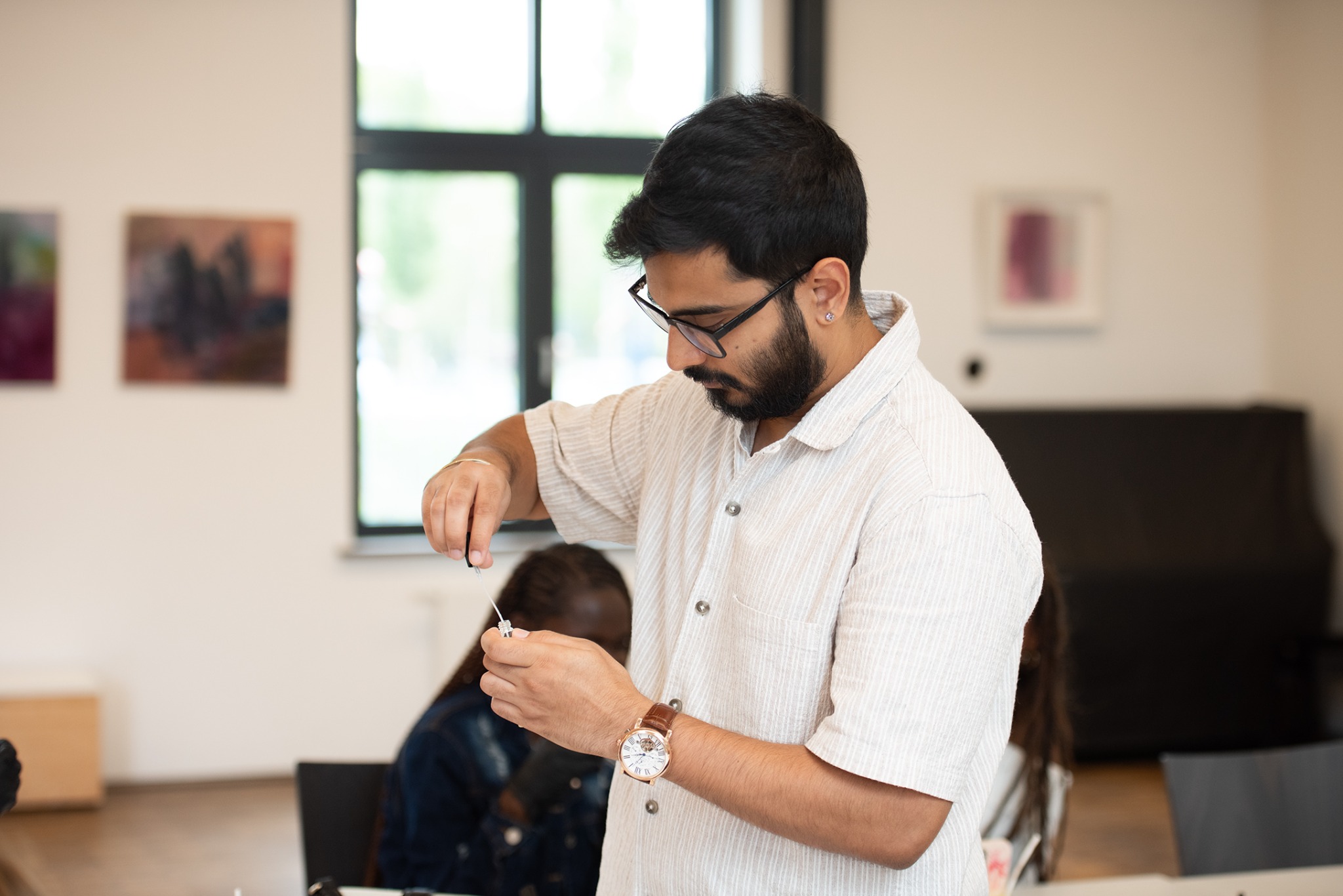 Sarthak carefully working with a perfume vial and pipette during a scent workshop